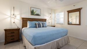 ein Schlafzimmer mit einem blauen Bett und einem Spiegel in der Unterkunft Modern and Coastal Ocean Pointe 2307 in Key Largo + 37 Fotos