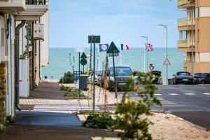 a street with cars parked next to the ocean at Appartement proche de la plage de Tanchet, quartier des Présidents Les Sables - 6 personnes in La Rudelière