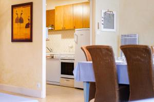 a kitchen with a table and chairs and a refrigerator at Appartement proche de la plage de Tanchet, quartier des Présidents Les Sables - 6 personnes in La Rudelière