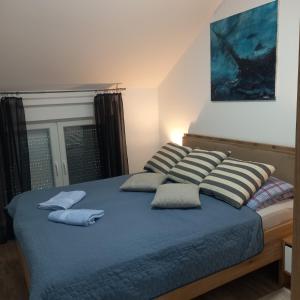 un letto con tre cuscini sopra di Apartman Prodan a Sombor