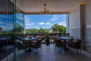 IsioloIman Hotel的有桌椅和大窗户的餐厅