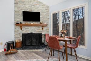a living room with a table and chairs and a fireplace at Laurelwood 43 with Wintergreen Advantage in Wintergreen