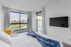 una camera da letto con un letto e una TV a schermo piatto di CoHost Casa Conceito Raiz da Serra IV a Gravatá Altre 51 foto