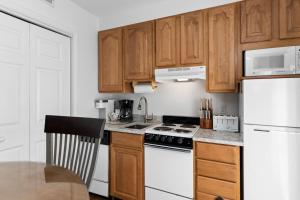 a kitchen with white appliances and wooden cabinets at Laurelwood 25 with Wintergreen Advantage in Wintergreen