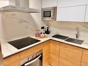 a kitchen with a sink and a stove top oven at Primera linea de playa Apartamento ELENI in Estepona