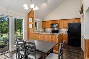 Il comprend une cuisine équipée d'une table et d'un réfrigérateur noir. dans l'établissement Eagles Court 24 with Wintergreen Advantage, à Wintergreen
