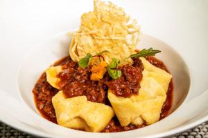 a white bowl of food with chili and pasta at Sheraton Guayaquil in Guayaquil +183 photos