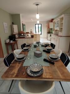 La Chapelle-aux-BoisGîte Domaine du Bagnerot的厨房里一张木桌,上面放有盘子和玻璃杯