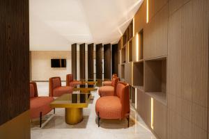 a waiting room with orange chairs and tables at Byon Hotel Şile in Şile