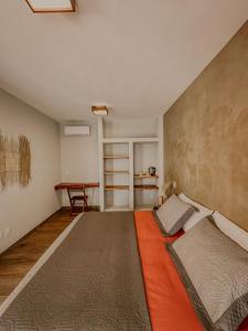 a bedroom with an orange bed and a table at La Maison Loosaï - Quarto em Pousada sem TV in Itacaré