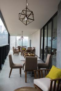 a living room with chairs and tables and a chandelier at ParkLife Santa Fe in Mexico City