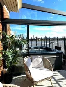 - Balcón con bañera de hidromasaje y silla en 3 x Bedroom Riverside Flat with HOT TUB on Roof Terrace, en Londres