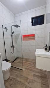 a bathroom with a shower and a toilet and a sink at Mi Refugio in San Fernando de Monte Cristi
