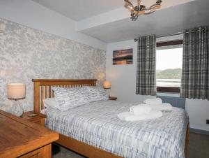 a bedroom with a bed and a window at Drysgol Lakeside - Bala Lake in Bala