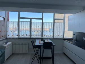 a kitchen with a table and chairs and windows at Malteses in A Guarda