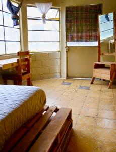 a bedroom with a bed and a table and a desk at Casa I`X in Quetzaltenango