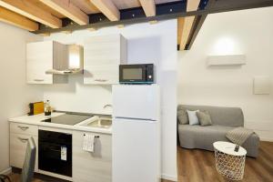a kitchen with a refrigerator and a couch in a room at Loft dal design raffinato a Vigonovo in Fontanafredda