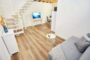 a living room with a couch and a television at Loft dal design raffinato a Vigonovo in Fontanafredda