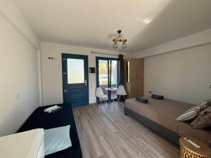 a bedroom with a bed and a table with chairs at Mare Calmo Studios, Chios in Chios