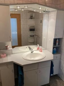 a bathroom with a sink and a mirror at Gemütliche Wohnung nähe Europapark Rust Offenburg Straßburg in Neuried +5 photos