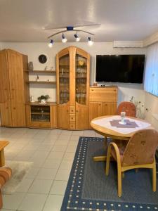 a living room with a table and a tv at Gemütliche Wohnung nähe Europapark Rust Offenburg Straßburg in Neuried