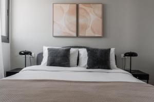 a bedroom with a large bed with two tables at Blueground Florentine, City view in Tel Aviv
