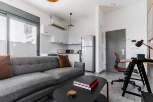 a living room with a couch and a table at Blueground Florentine, City view in Tel Aviv