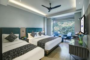 a hotel room with two beds and a window at HOTEL UPTOWN - Luxury Restaurant & Rooftop Near Connaught Place in New Delhi +39 photos