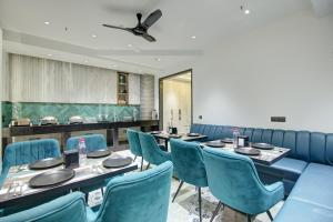 a dining room with blue chairs and tables at HOTEL UPTOWN with Luxury Restaurant & Rooftop Near Connaught Place, New Delhi City Centre in New Delhi