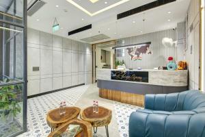 a lobby with a blue couch and tables at HOTEL UPTOWN - Luxury Restaurant & Rooftop Near Connaught Place in New Delhi