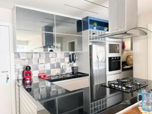 a kitchen with a sink and a refrigerator at Apartamento de Luxo em Guarapari in Guarapari