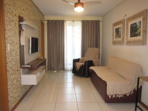 a living room with a couch and a tv at Residence 207 Cabo Branco in João Pessoa