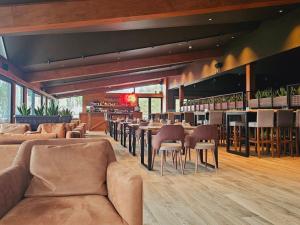 a restaurant with tables and chairs and a bar at Grand Chamois Hotel & Spa in Mavrovo