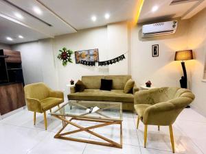 a living room with a couch and two chairs and a table at Lavish Luxury in Rāmkot