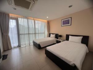 a hotel room with two beds and a window at Minh Khang Hotel in Ho Chi Minh City