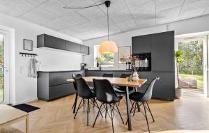 a kitchen with a wooden table and black chairs at 3 Bedroom Cozy Home In Ringkøbing in Ringkøbing