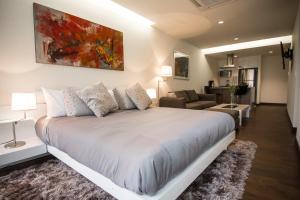 a bedroom with a large bed and a living room at ParkLife Santa Fe in Mexico City