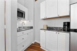 a kitchen with white cabinets and a sink at Mountain Inn Studio 92 with Wintergreen Advantage in Wintergreen +9 photos