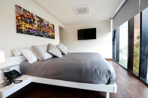 una camera con letto e TV a parete di ParkLife Santa Fe a Città del Messico