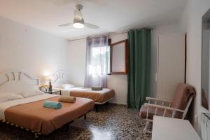 a bedroom with two beds and a window with green curtains at Eco-hotel Aire de Monte in Náquera +22 photos