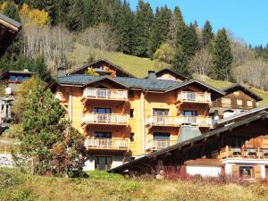 a large wooden building with balconies on a hill at Appartement Cosy 3 pièces avec Balcon, Garage et Wi-Fi - FR-1-598-40 in Les Gets