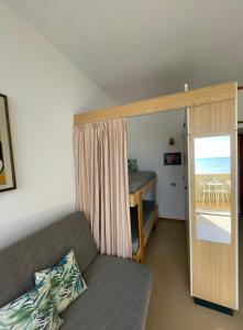 een woonkamer met een bank en een slaapkamer bij Apartament Mare e Sole z basenem i przy plaży in Marotta