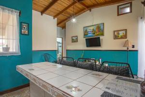 Un comedor con una mesa y una pared azul. en Casa Chelis, en Fortuna