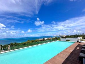 a swimming pool with a view of the ocean at New apartment Neen in Cancún