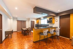 a kitchen and dining room with a yellow counter and chairs at Tropicana Suites in Manila