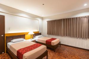 a hotel room with two beds and a window at Tropicana Suites in Manila +102 photos