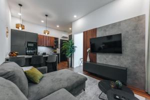 a living room with a couch and a television on a wall at Studio apartmani Albero in Ivanić-Grad