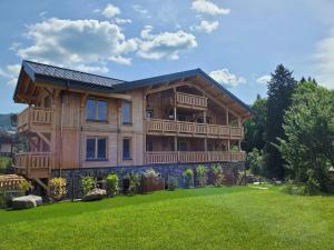 a large wooden house with a large yard at Appartement lumineux 3* avec terrasse, 2 chambres, proche centre et pistes, garage inclus - FR-1-598-163 in Les Gets