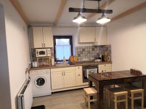 a kitchen with white cabinets and a table and a sink at Parittyaház in Homokmégy