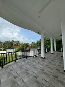 a large white porch with a black fence at Sambo White House Hikkaduwa - 5BD Entire Villa in Galle